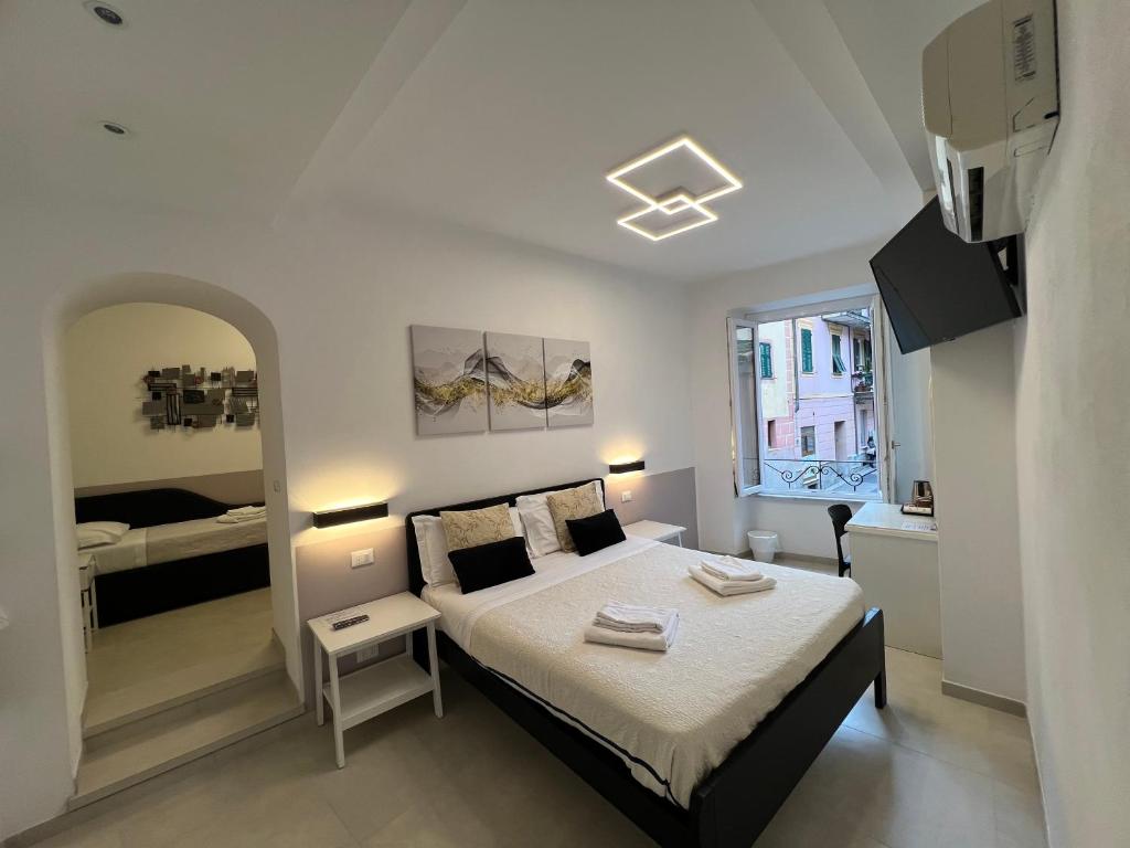 a white bedroom with a bed and a window at Affittacamere Sull'Arco in Monterosso al Mare