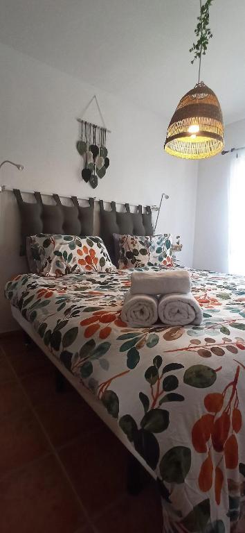 a bedroom with a bed with a floral comforter at My casa Lanzarote in Costa Teguise