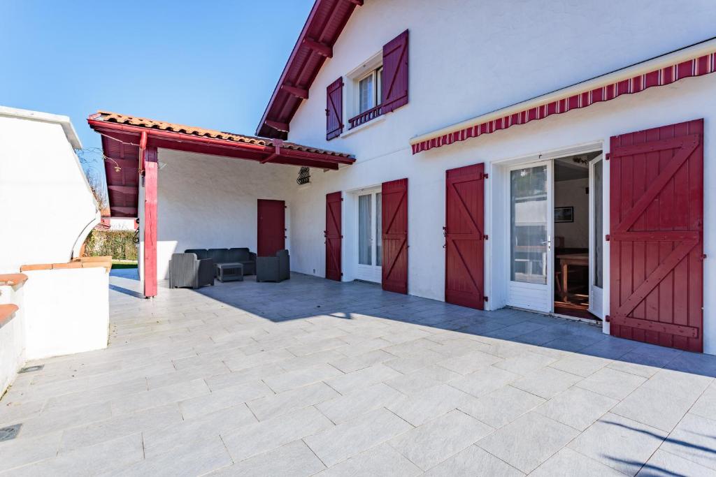 un garage avec des portes rouges sur une maison dans l'établissement Maison à la campagne et à 15mn des principales villes de la côte, à Briscous