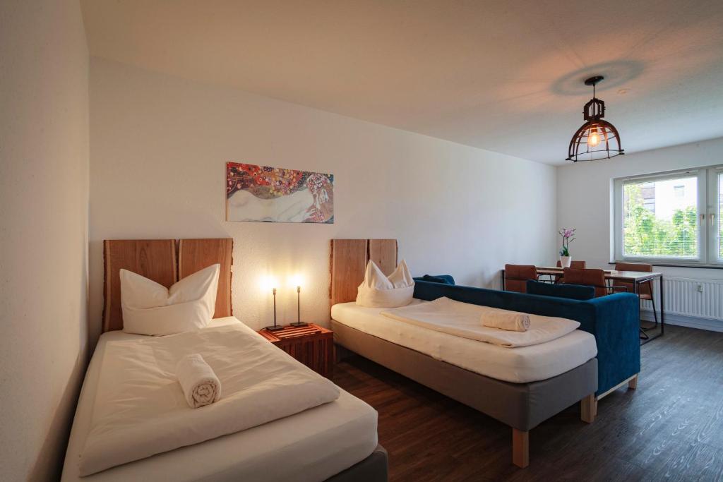 ハノーファーにあるMesse Apartment Hannoverのベッドルーム1室(ベッド2台、青いソファ付)
