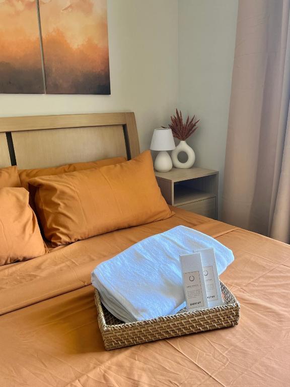 a bed with a basket of towels on it at Condo in Lapu-Lapu City in Lapu Lapu City