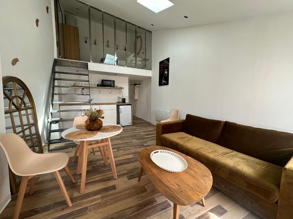 sala de estar con sofá y 2 mesas en Charmant Loft moderne au coeur de Hyères, en Hyères