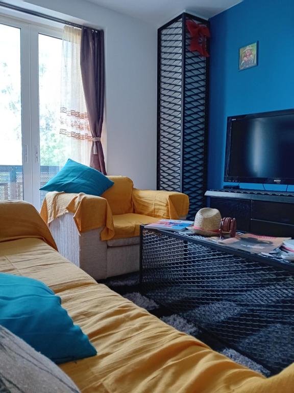 a living room with two beds and a flat screen tv at Down town house with uni sence! in Athens