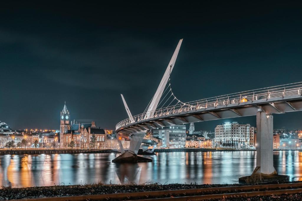 un ponte sull'acqua con una città di notte di Hotel No.9 a Londonderry