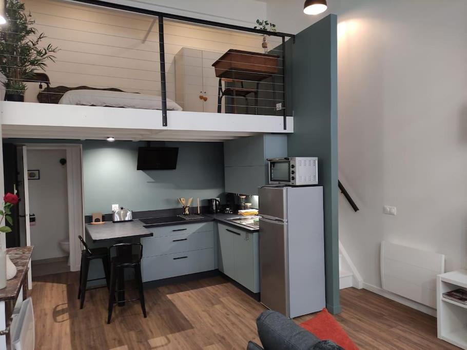 a kitchen with a loft bed and a kitchen with a table at ღ Le Loft • Spacieux, Situé au cœur de Douai in Douai