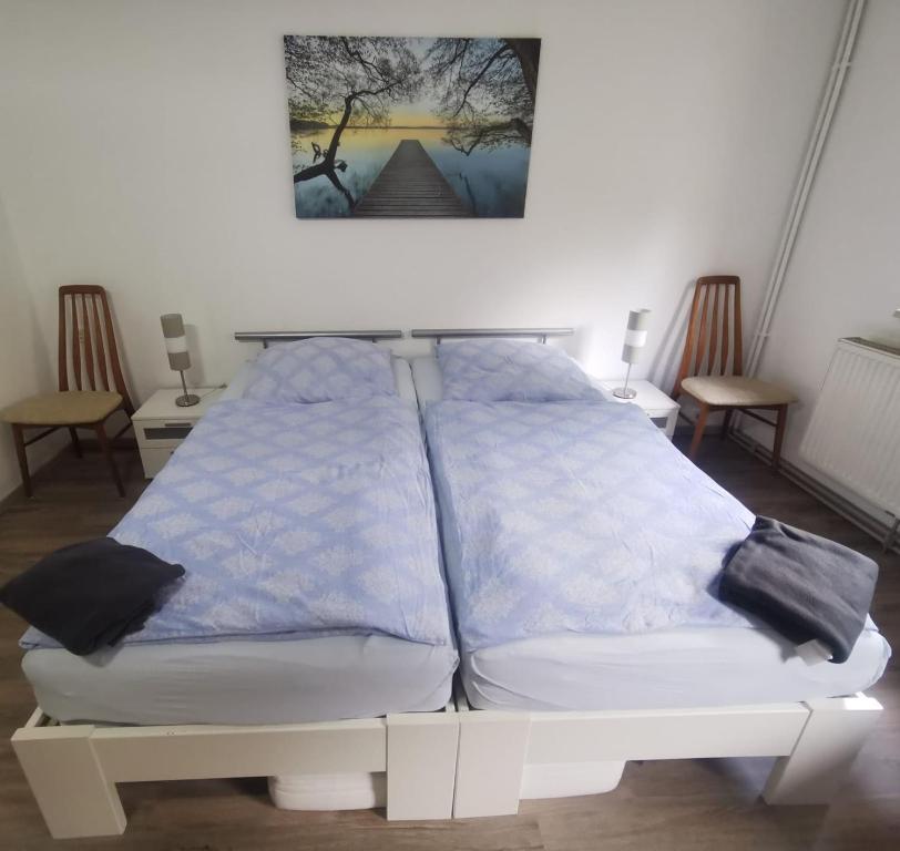 a white bed with blue sheets and pillows on it at Große Ferienwohnung 80qm 1 Schlafzimmer max 3 Gäste in Coppenbrügge