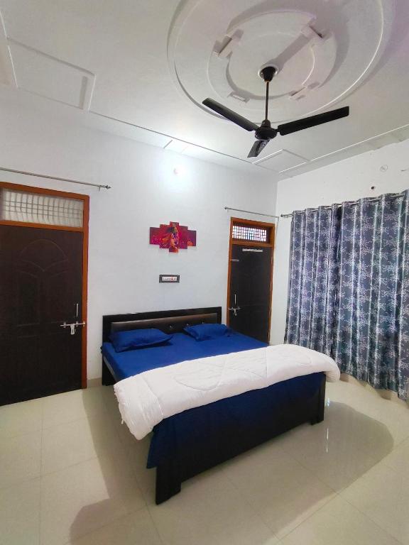 - une chambre avec un lit et un ventilateur de plafond dans l'établissement SiyaRam Homestay, à Faizābād