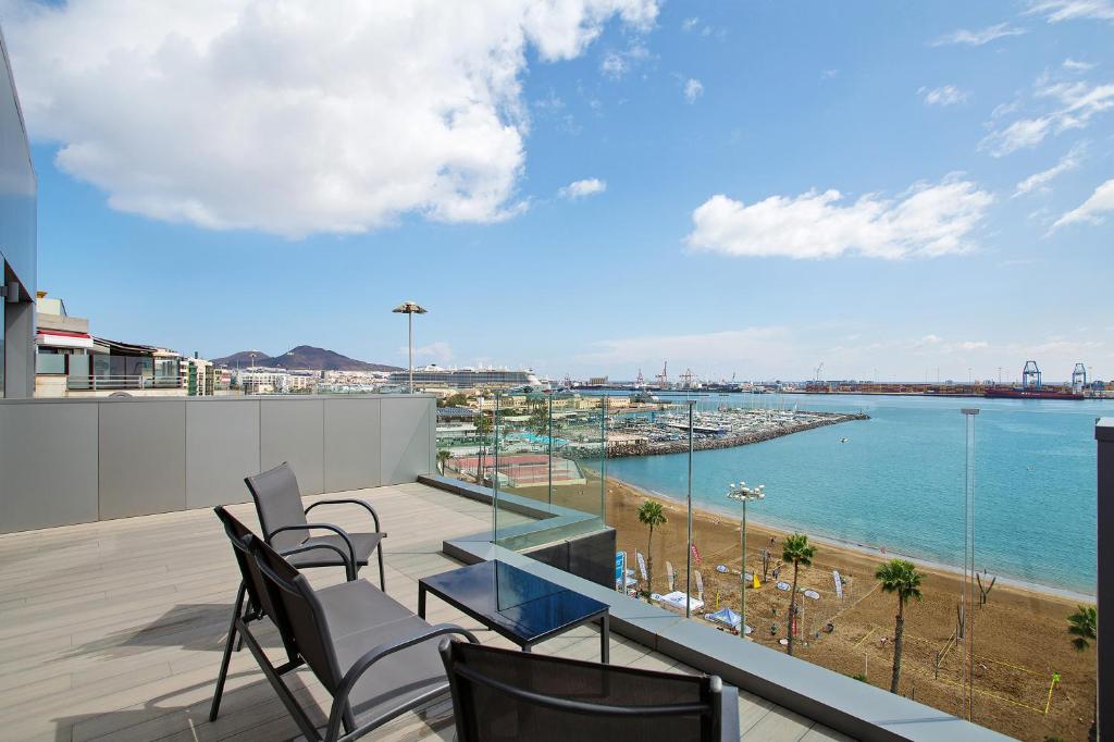 een balkon met stoelen en uitzicht op het water bij Wonderful penthouse city and beach in Las Palmas de Gran Canaria