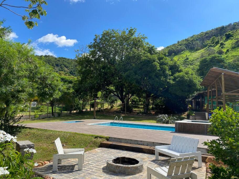 eine Terrasse mit 2 Stühlen und einem Pool in der Unterkunft Rancho Vida Boa in Santana do Paraíso