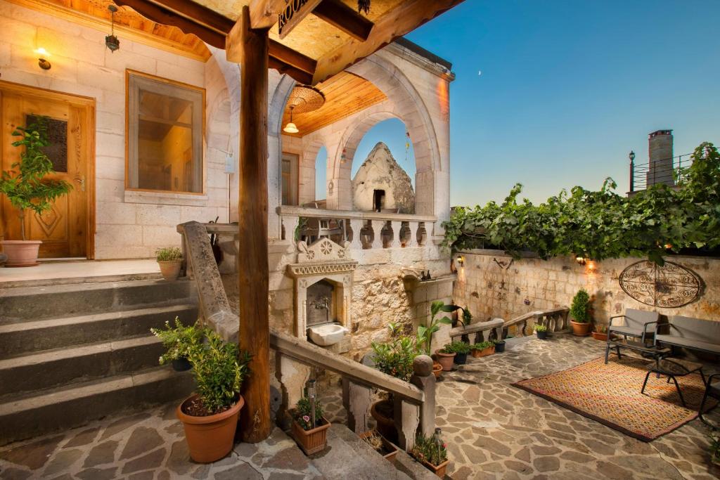 a house with a stone fireplace in a yard at PERİ CAVE KONAK in Nevsehir