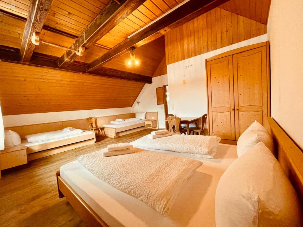 two beds in a large room with wooden ceilings at Gästehaus Spoth in Rust