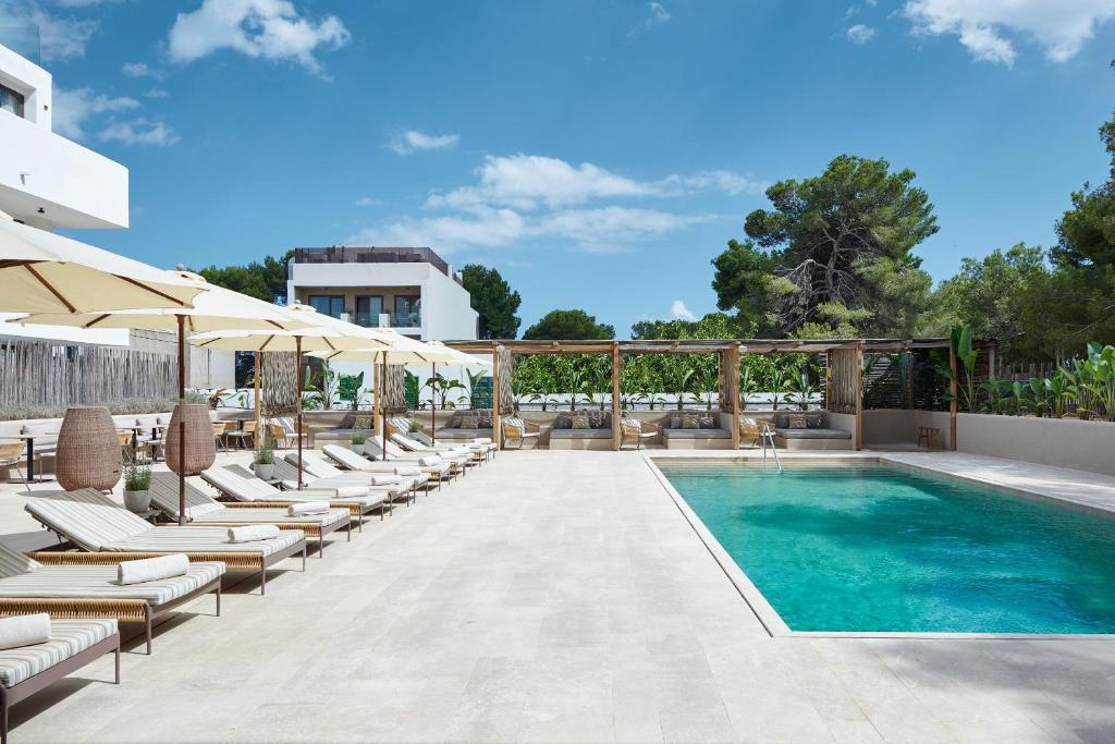 una piscina con tumbonas y sombrillas en Barefoot Hotel Mallorca en Portocolom