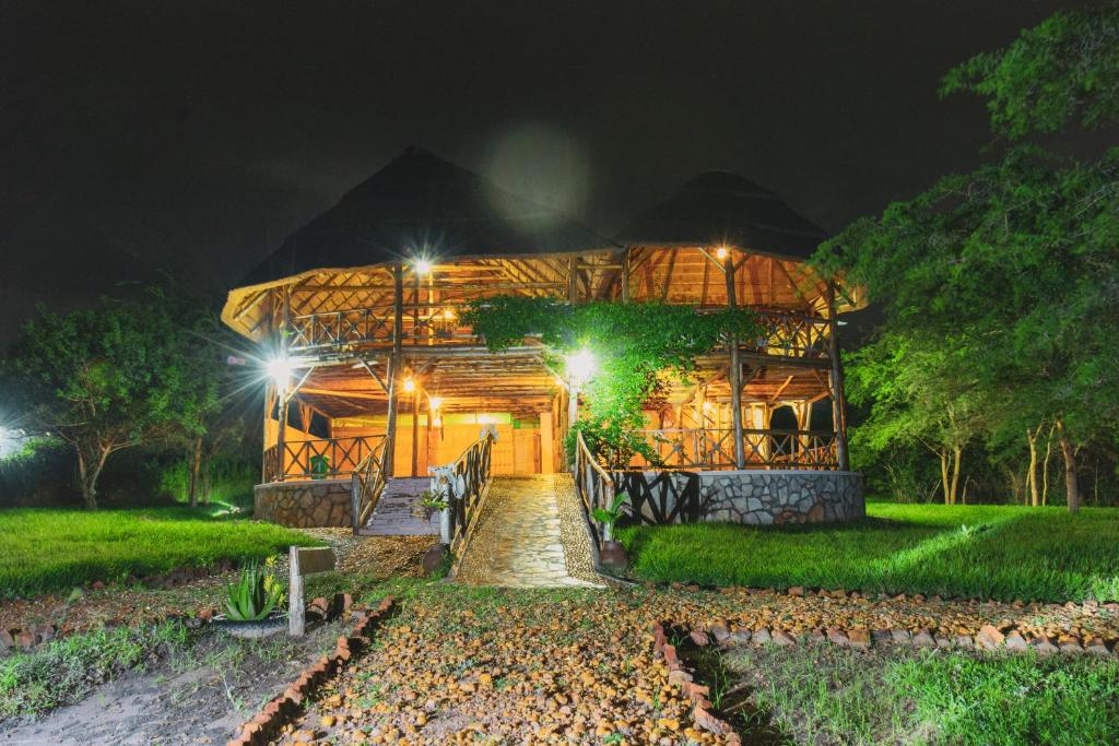 Una casa de noche con luces encendidas. en Elephant View Lodge, en Kasenyi