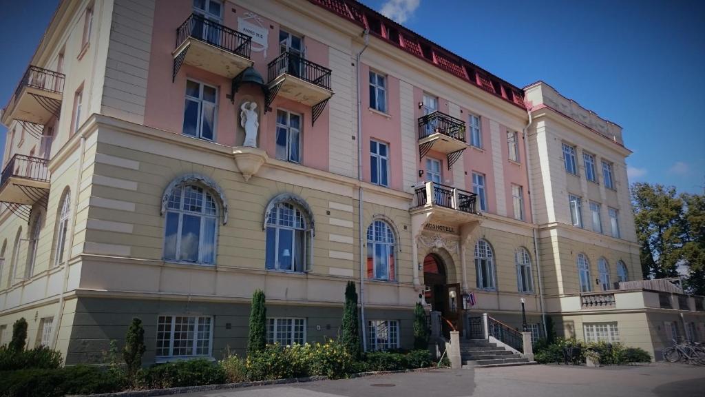 a large pink building with stairs in front of it at Stadshotellet Sölvesborg in Sölvesborg