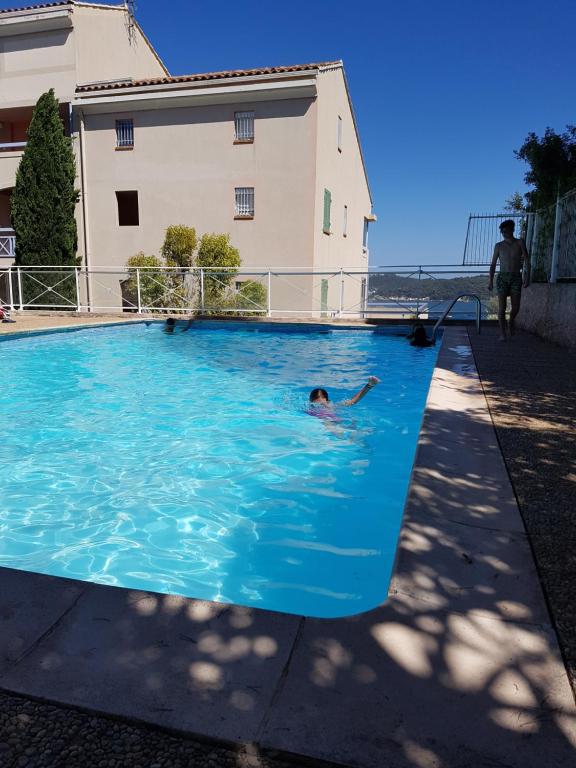une personne nageant dans une grande piscine bleue dans l'établissement les marines de Tamaris, à La Seyne-sur-Mer