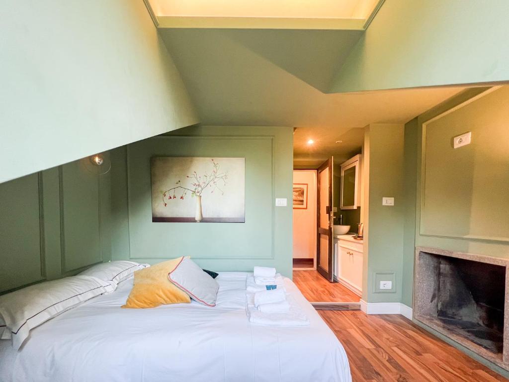 um quarto com uma grande cama branca e uma lareira em Vittorio Attic Room em Turim