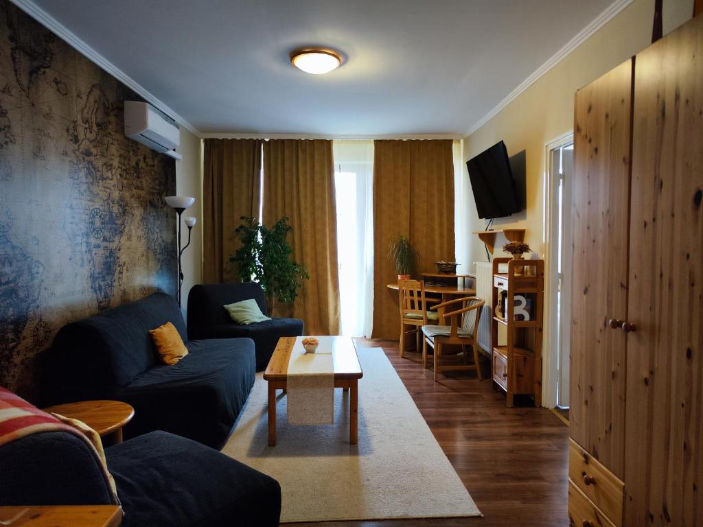 a living room with a couch and a table at St. Benedek Apartmanlakás in Mezőkövesd