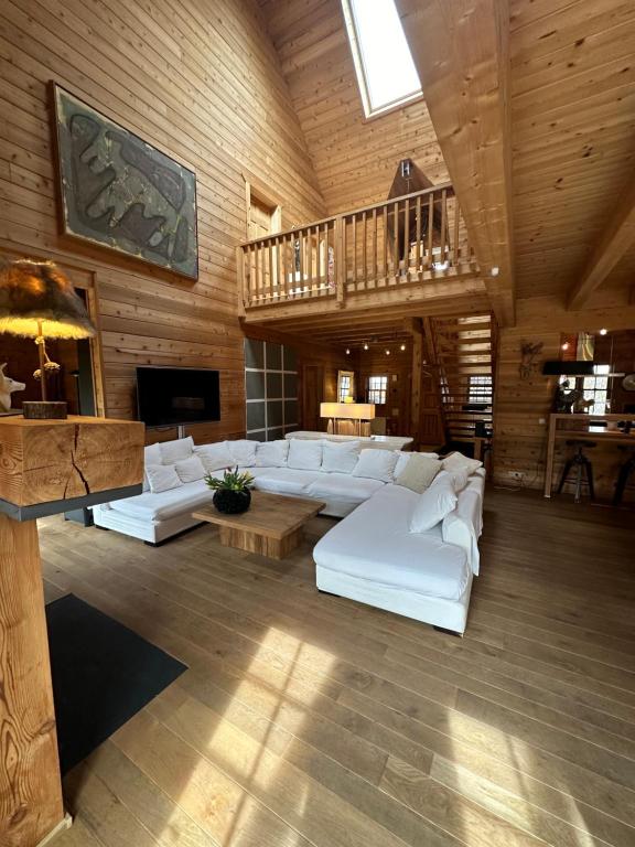 a large living room with white couches and a wooden ceiling at EifelChalet Arduina mit Wintergarten und Saunahaus im Naturpark Hohes Venn- Eifel in Hellenthal