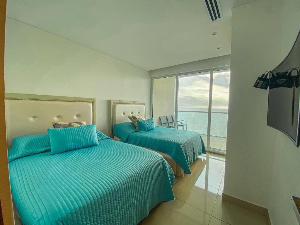 two beds in a room with a view of the ocean at hyatt(H2)luxury in Cartagena de Indias