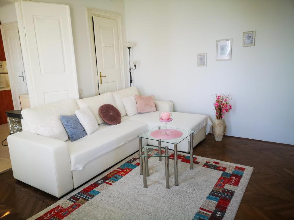 a living room with a white couch and a table at APARTMENT VOLOSKO - 50m to the sea in Opatija