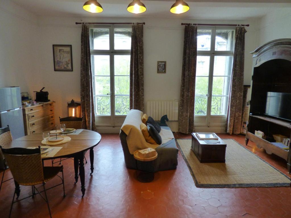 een woonkamer met een bank en een tafel bij "Le Bouquet de Pézenas" Wifi-Garage privé optionnel Centre historique-Plages à 21km ! in Pézenas