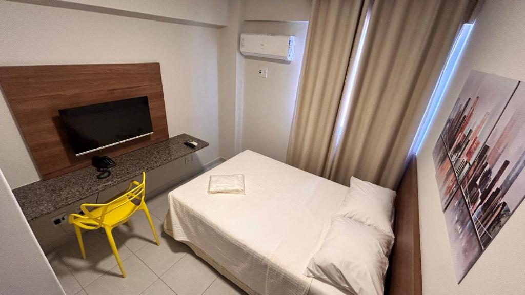 a small room with a bed and a television at NORTH HOTEIS in Montes Claros