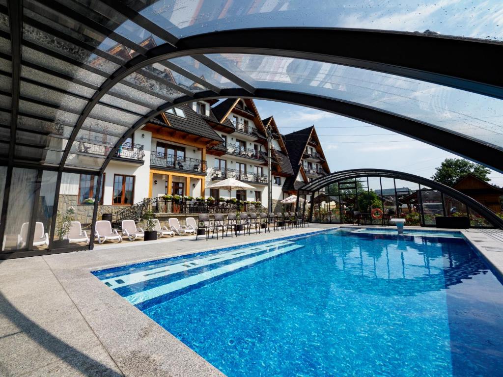 a swimming pool with an archway over it at Hotel Liptakówka in Białka Tatrzanska