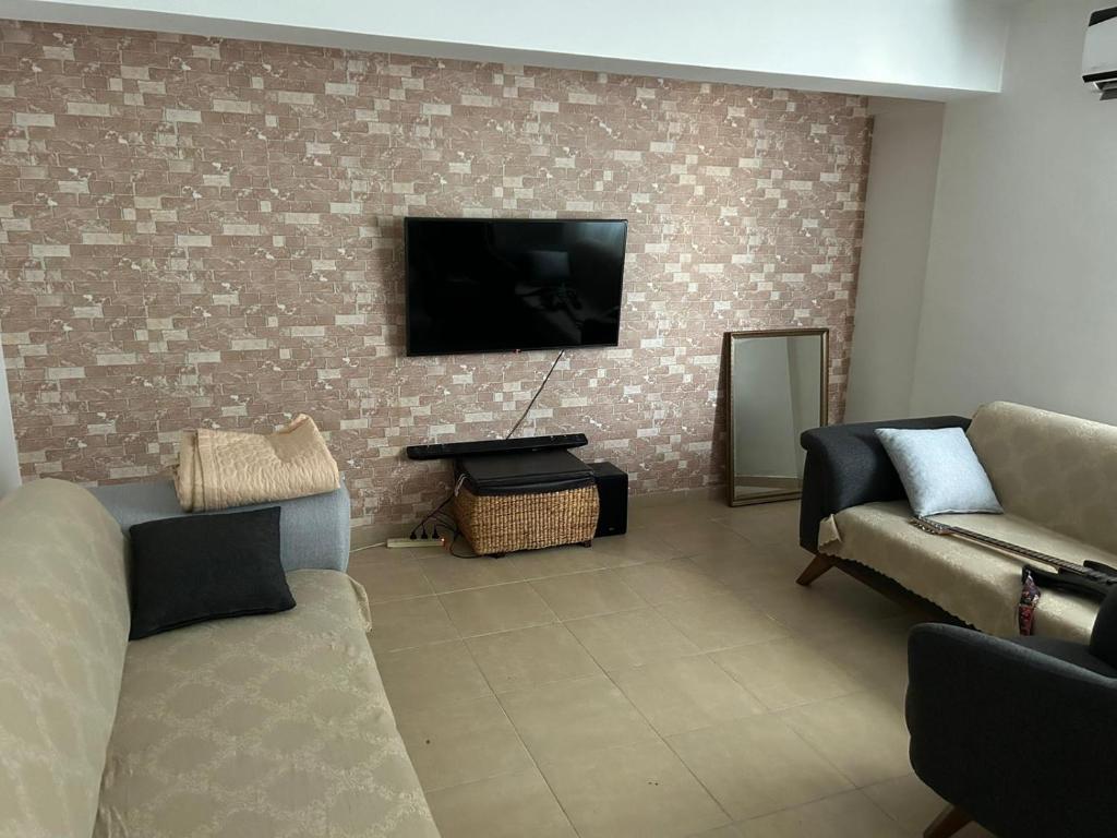 a living room with two couches and a flat screen tv at Özel Mülk in Famagusta