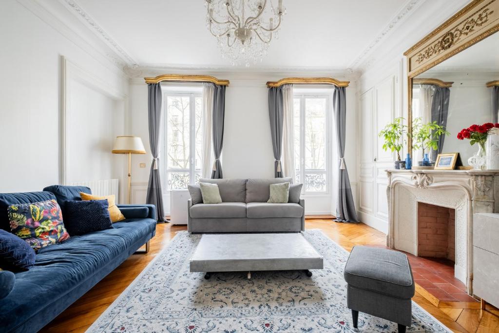 un salon avec un canapé bleu et une cheminée dans l'établissement Veeve - Porcelain Pelouse, à Paris