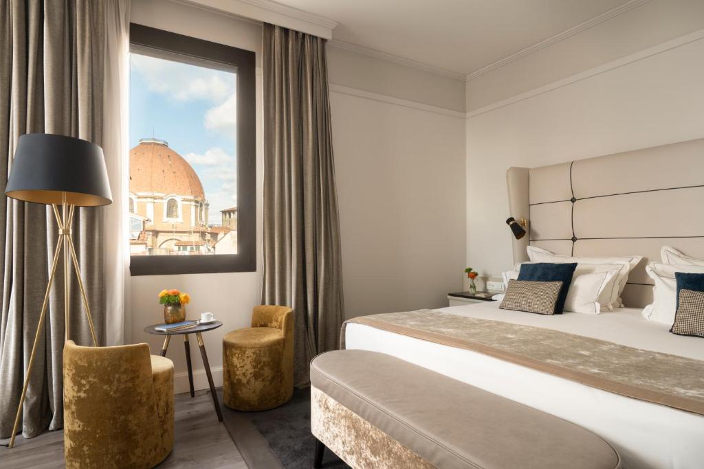 ein Hotelzimmer mit einem großen Bett und einem Fenster in der Unterkunft Hotel Cerretani Firenze - MGallery Collection in Florenz