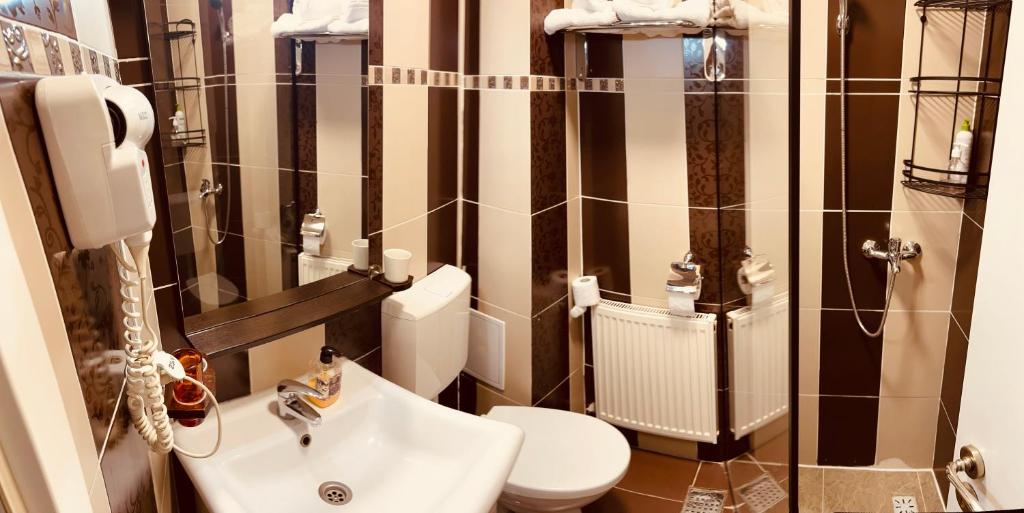 a bathroom with a toilet and a sink at Hotel Zava Boutique Central in Bucharest