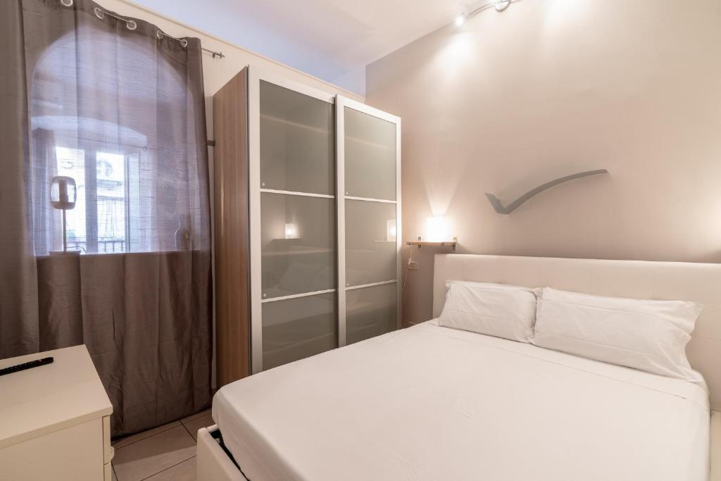 een slaapkamer met een wit bed en een raam bij Santa Maria Maggiore Apartment in Barletta
