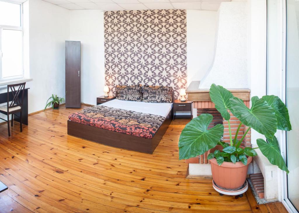a living room with a bed and a wooden floor at Sofia Central Guest Rooms in Sofia