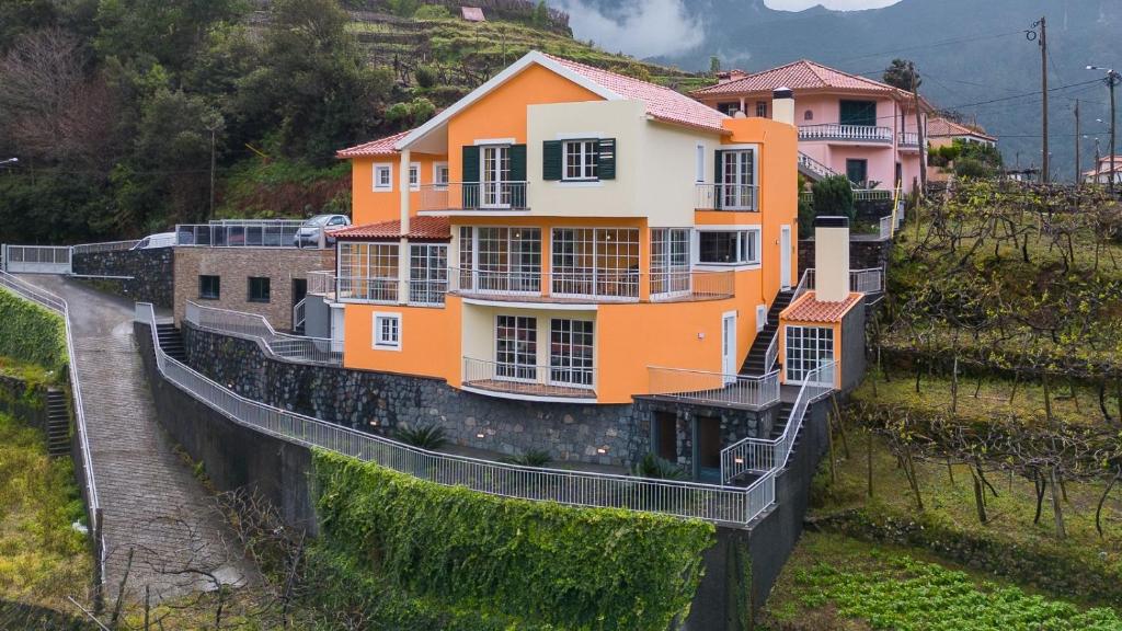 een oranje en wit huis bovenop een heuvel bij The Mountain View, By OP in São Vicente