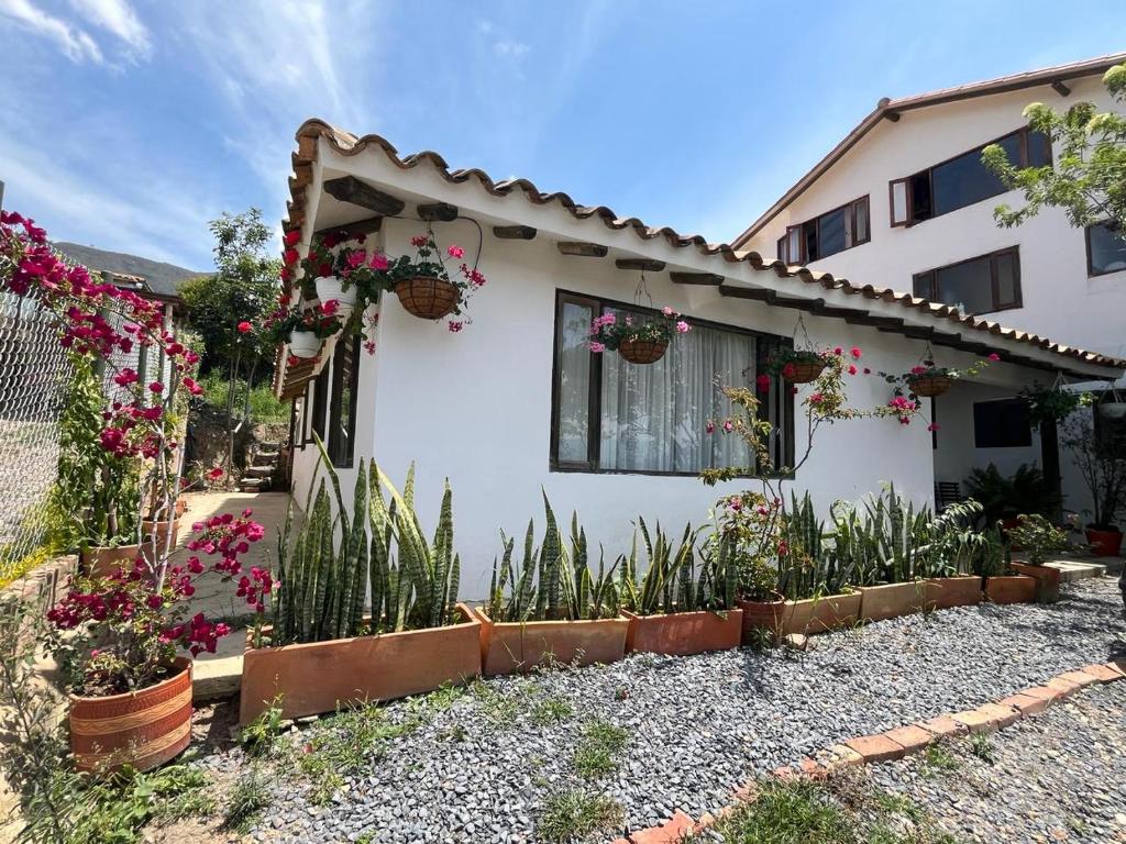 a white house with flowers in front of it at Cabaña Lewana Campestre in Villa de Leyva