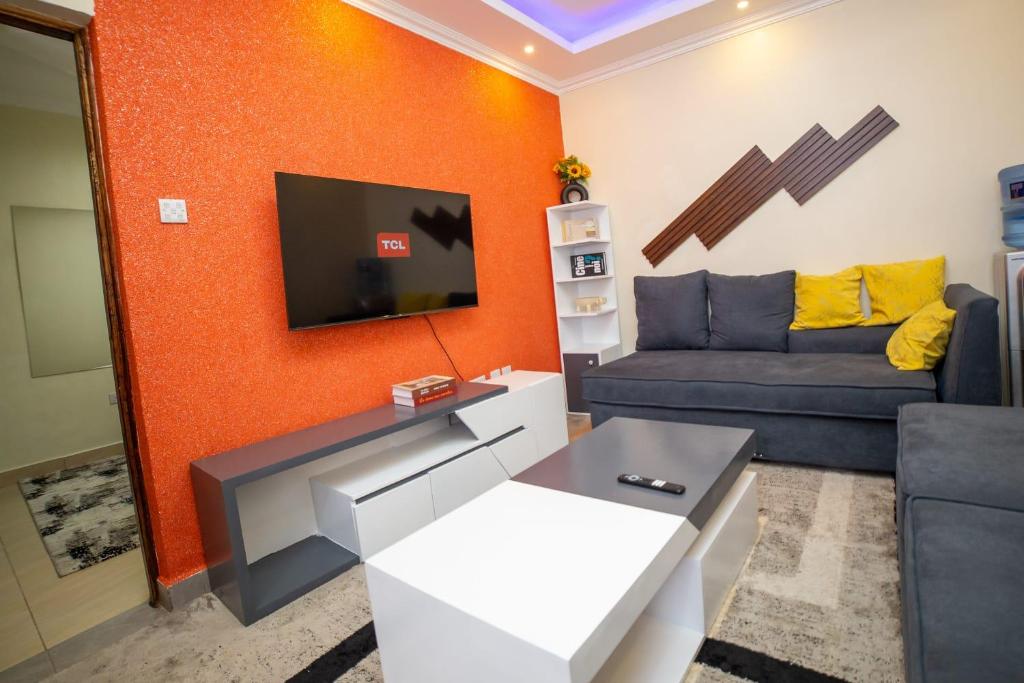 ein Wohnzimmer mit einem Sofa und einem TV in der Unterkunft Tegera Homes in Kericho