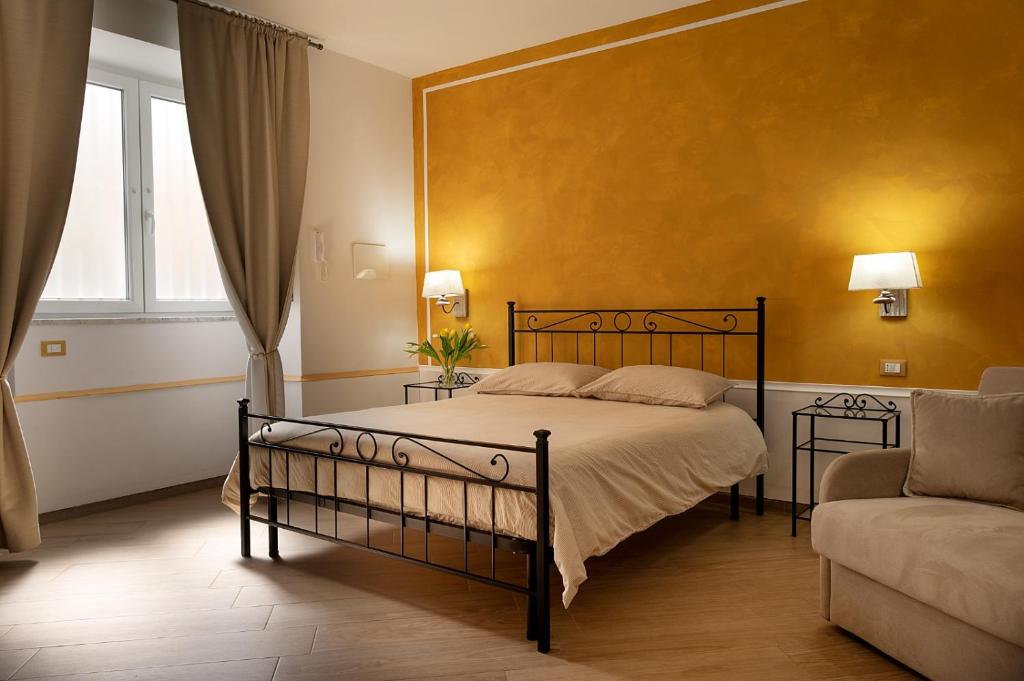 a bedroom with a bed and a yellow wall at Domus Cuomo B&B in Nocera Inferiore