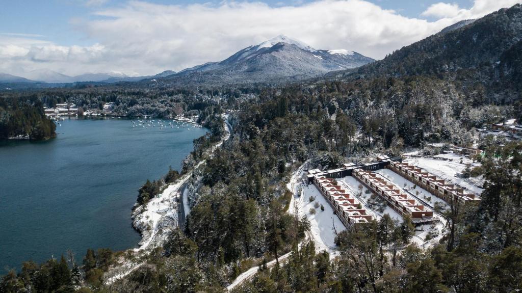 eine Luftansicht eines Resorts neben einem See und einem Berg in der Unterkunft Bahía Montaña Resort in Villa La Angostura