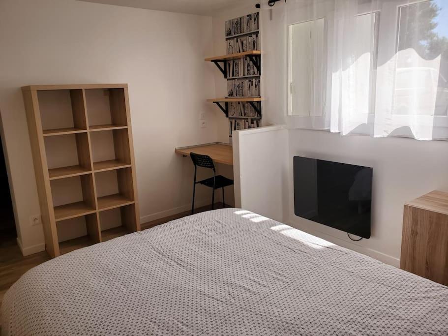 um quarto com uma cama e uma televisão de ecrã plano em La bastille 4 em Saintes