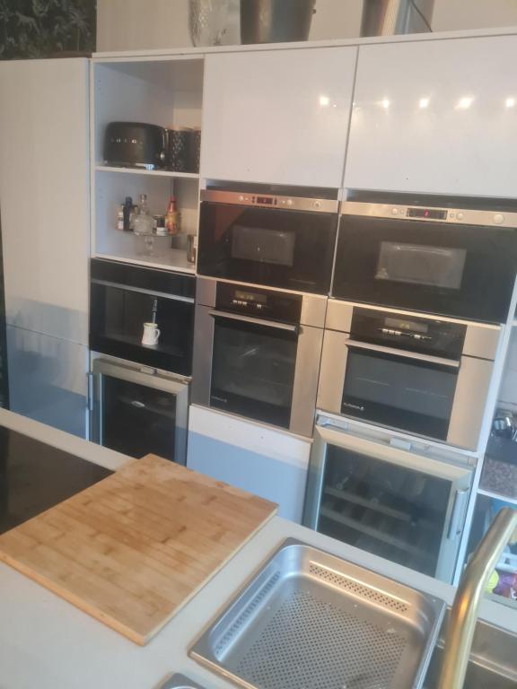 une cuisine avec quatre fours et une table en bois dans l'établissement au porte des j.o, à Paris