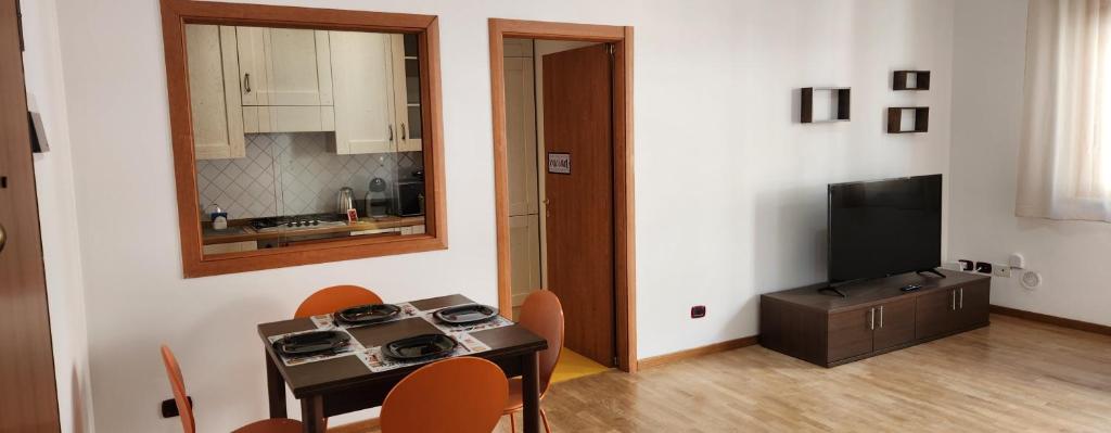 a room with a table and a kitchen with a television at Rotolo Suite 502 in Catania