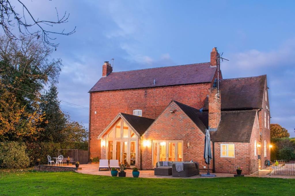 a large brick building with a patio in front of it at Bank Farm House - Stunning House & Gardens in Shenstone