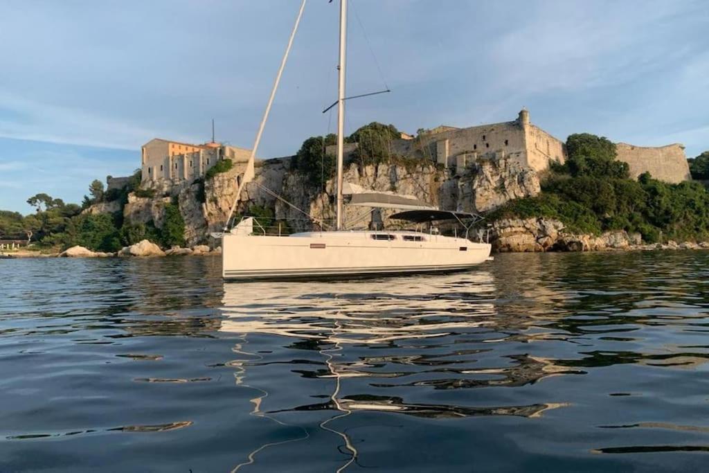 una barca a vela sull'acqua con un castello sullo sfondo di Idéal Lions - Dielli a Cannes