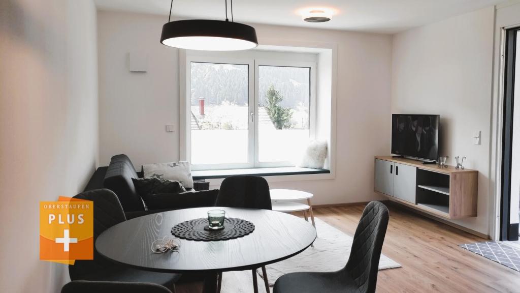 a living room with a table and chairs at FeWo Hochsiedelblick, Oberstaufen/Wiedemannsdorf in Oberstaufen