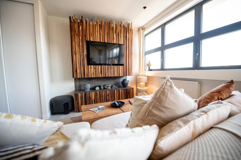 un salon avec un canapé et une télévision dans l'établissement Kasa Madura - Duplex au calme tout équipé, à Saint-Étienne