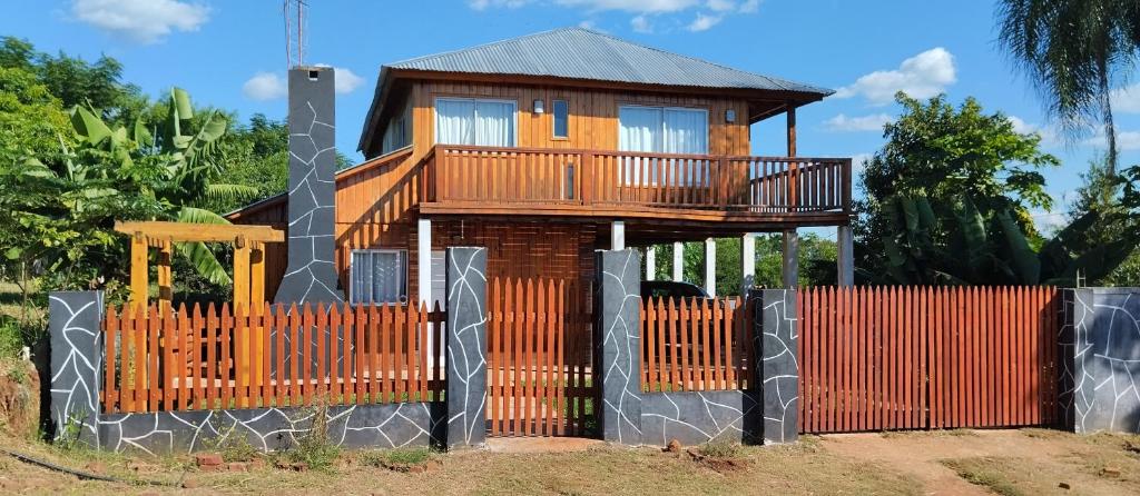 ein Baumhaus mit einem Zaun davor in der Unterkunft Cabañas Refugio Verde in El Soberbio