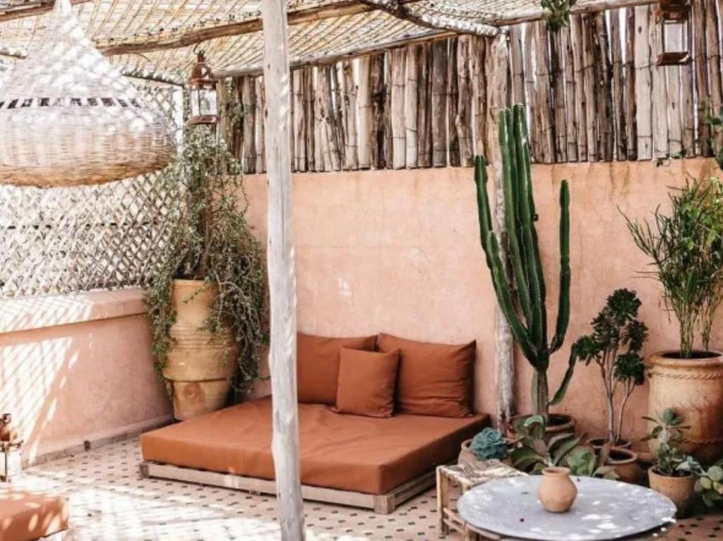 een patio met een bank en veel planten bij Oasis Urbaine - Cosy & Soleil in Taroudant