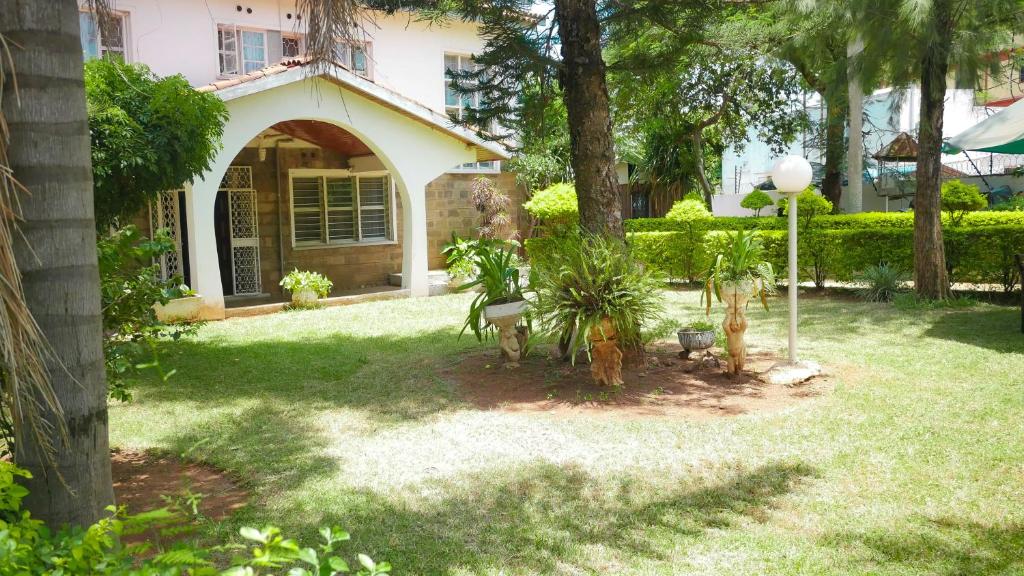 uma casa com um quintal com plantas em frente em VICTORIA RIPPLE HOTEL { WINAM } em Kisumu