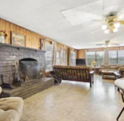 un soggiorno con camino e divano di Thunderbird Lodge a Burnet