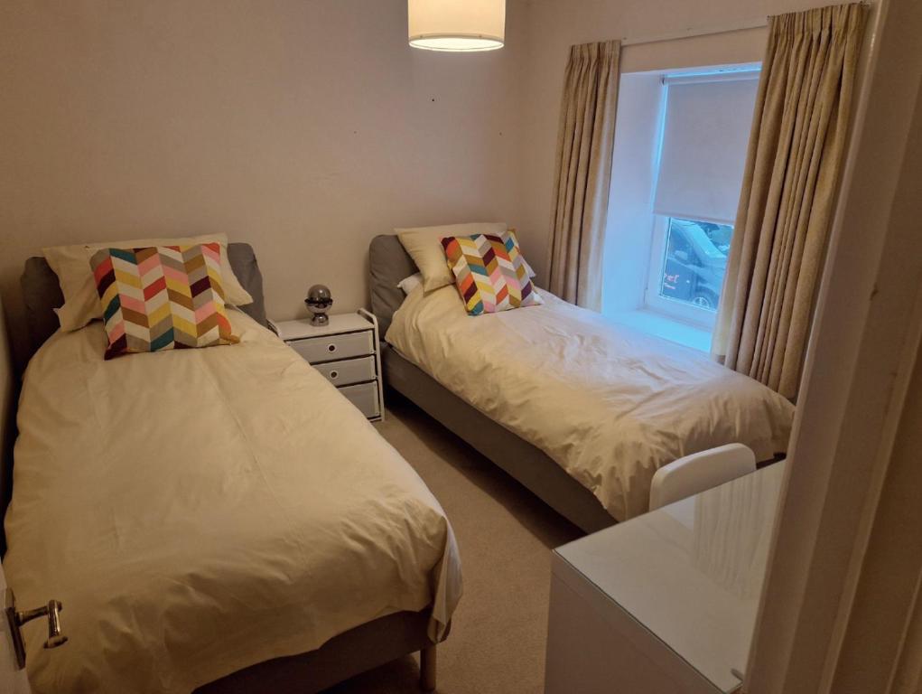 a bedroom with two beds and a window at Bridgend Rd. Maesteg in Garth